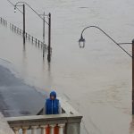 Un uomo si ripara dall'esondazione del fiume. Le arcate e le rimesse delle barche sono interamente sommerse dall'acqua. Un uomo si ripara dall'esondazione del fiume. Le arcate e le rimesse delle barche sono interamente sommerse dall'acqua.