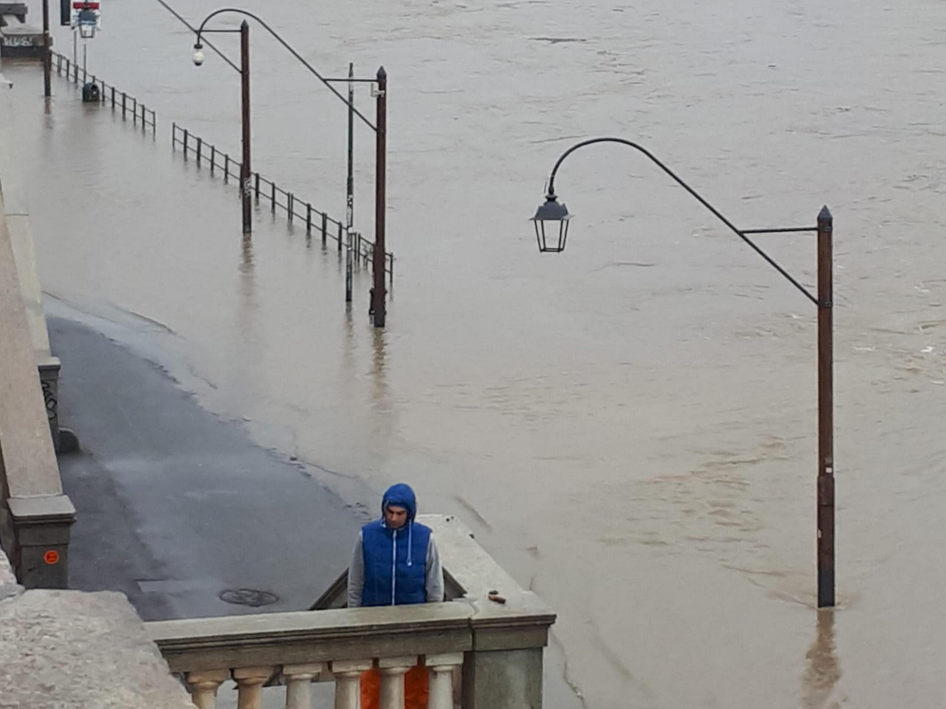 Un uomo si ripara dall'esondazione del fiume. Le arcate e le rimesse delle barche sono interamente sommerse dall'acqua. Un uomo si ripara dall'esondazione del fiume. Le arcate e le rimesse delle barche sono interamente sommerse dall'acqua.