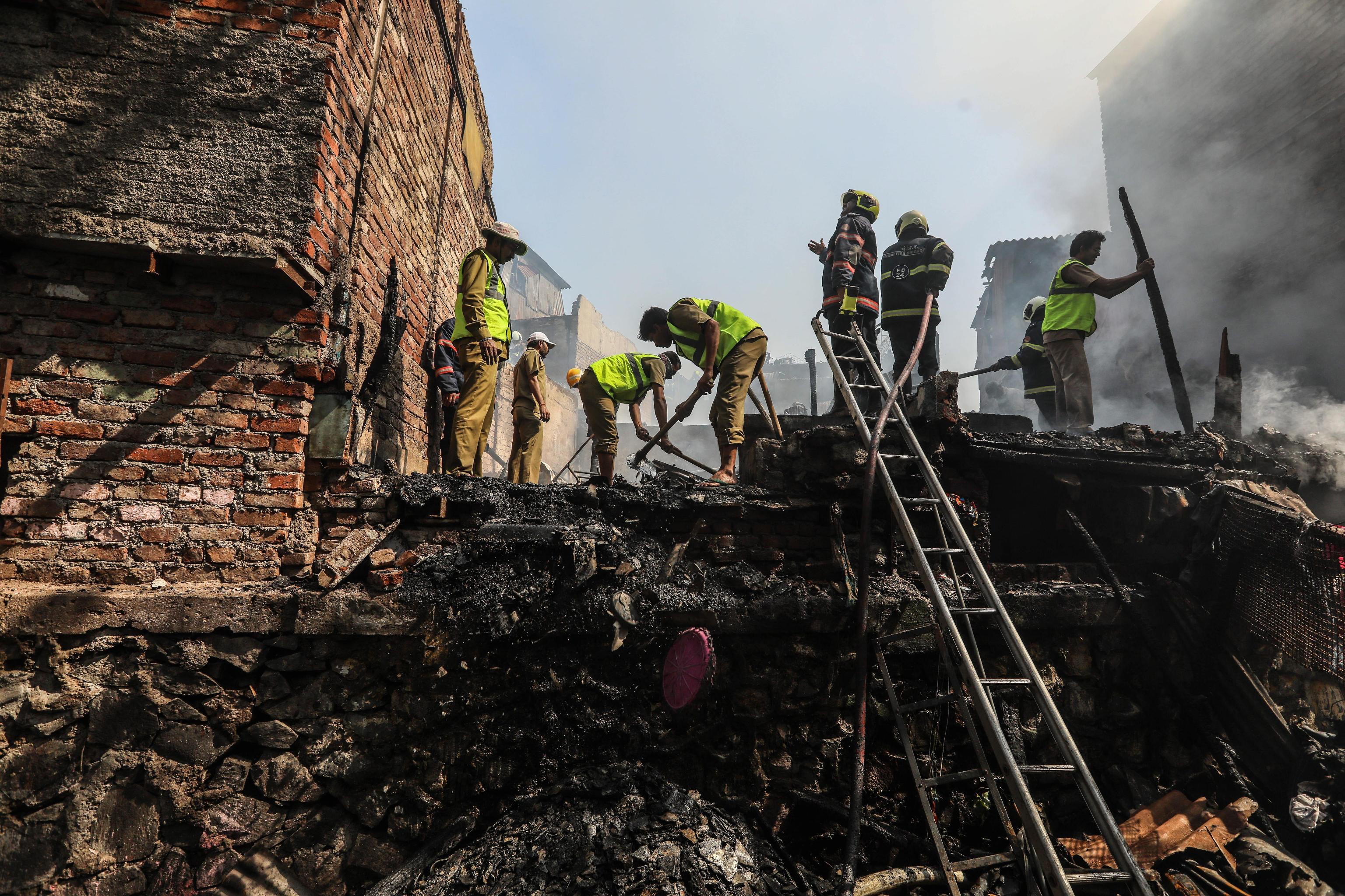 I pompieri indiani spengono l'incendio divampato oggi in una baraccopoli a Shashtri Nagar a Bandra (Mumbai)
