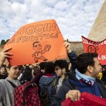 Due ragazzi alzano un cartello con la caricatura di Luigi Di Maio
