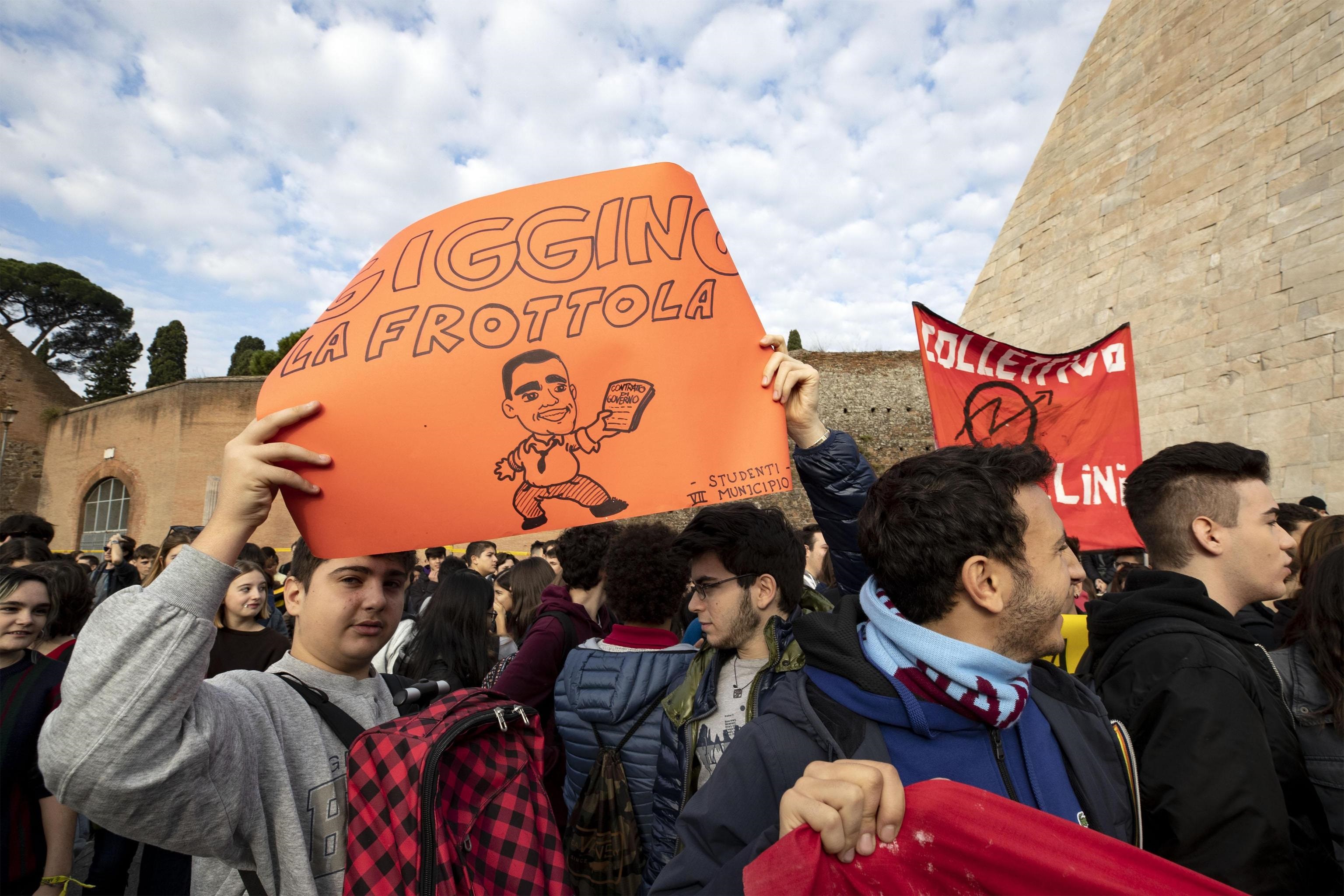 Due ragazzi alzano un cartello con la caricatura di Luigi Di Maio