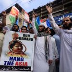 Manifestanti islamisti esibiscono cartelli contro Asia Manifestanti islamisti esibiscono cartelli contro Asia