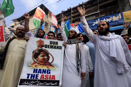 Manifestanti islamisti esibiscono cartelli contro Asia Manifestanti islamisti esibiscono cartelli contro Asia