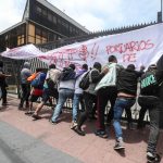 Un gruppo di operatori portuali a chiamata tenta di abbattere il cancello del porto di Valparaiso Un gruppo di operatori portuali a chiamata tenta di abbattere il cancello del porto di Valparaiso