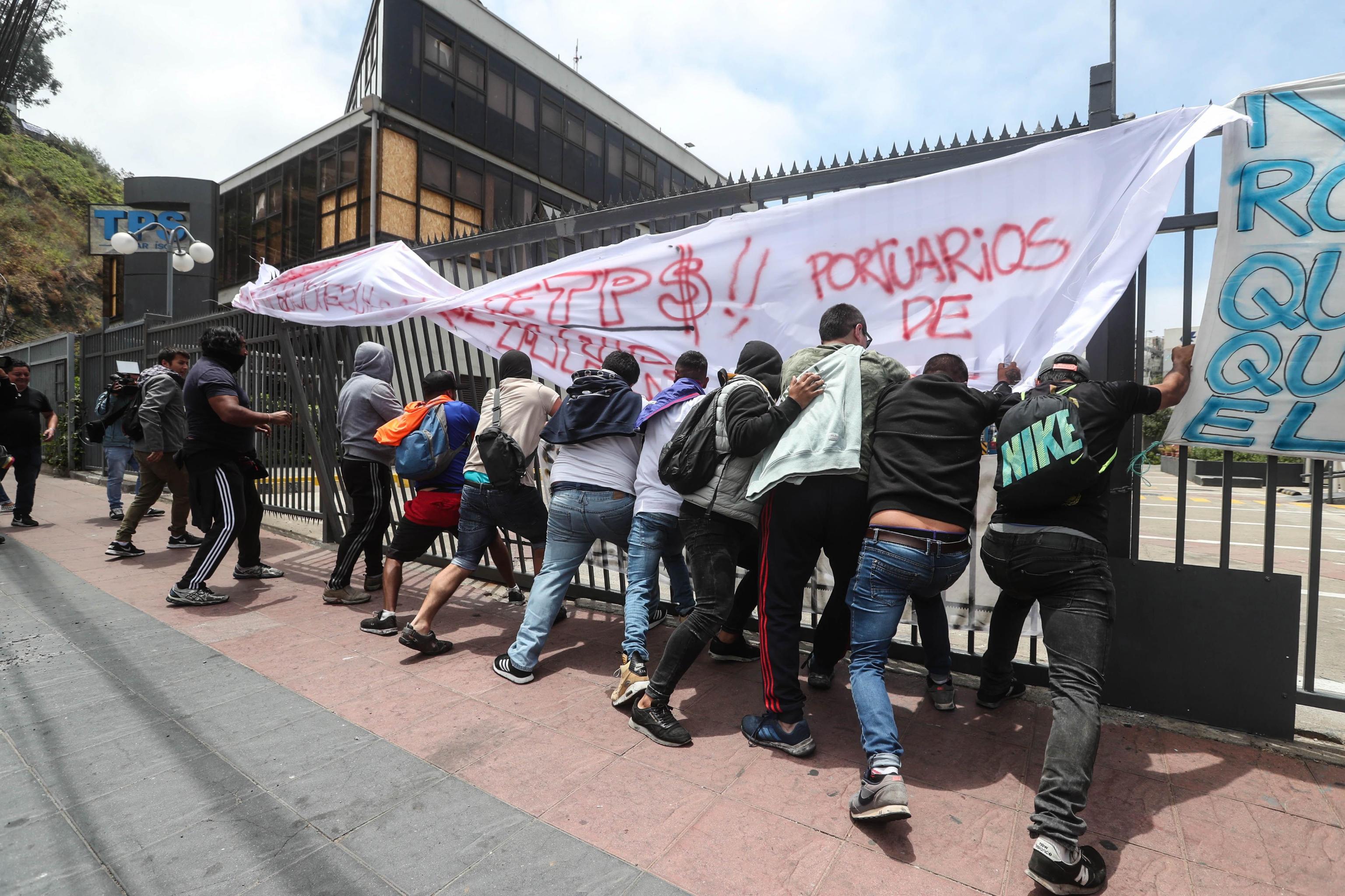 Un gruppo di operatori portuali a chiamata tenta di abbattere il cancello del porto di Valparaiso Un gruppo di operatori portuali a chiamata tenta di abbattere il cancello del porto di Valparaiso