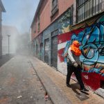 I gas lacrimogeni lanciati dalla polizia non frenano gli operai portuali, per l'occasione mascherati I gas lacrimogeni lanciati dalla polizia non frenano gli operai portuali, per l'occasione mascherati