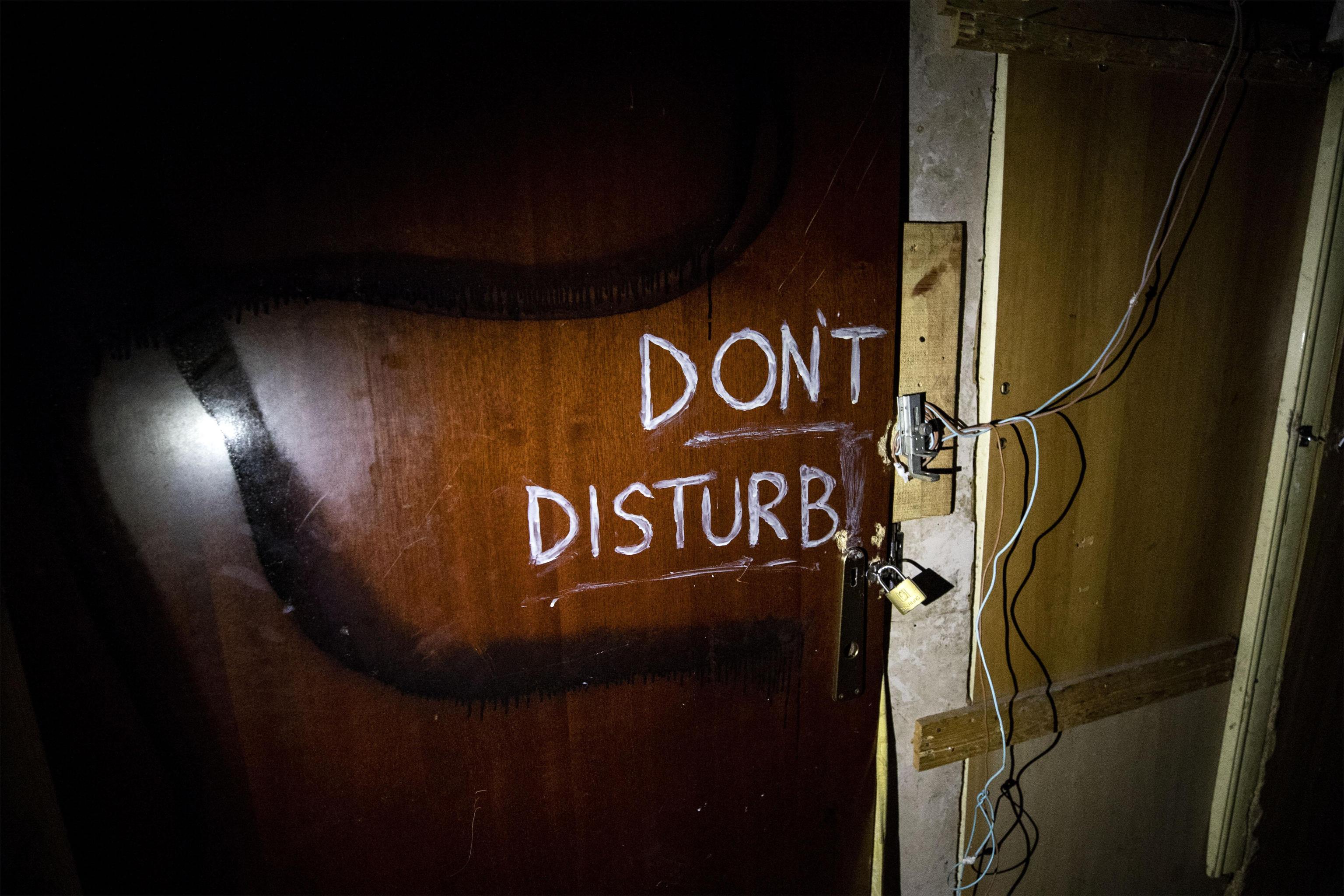 La frase "Don't disturb" all'interno dello stabile sgomberato oggi a Roma