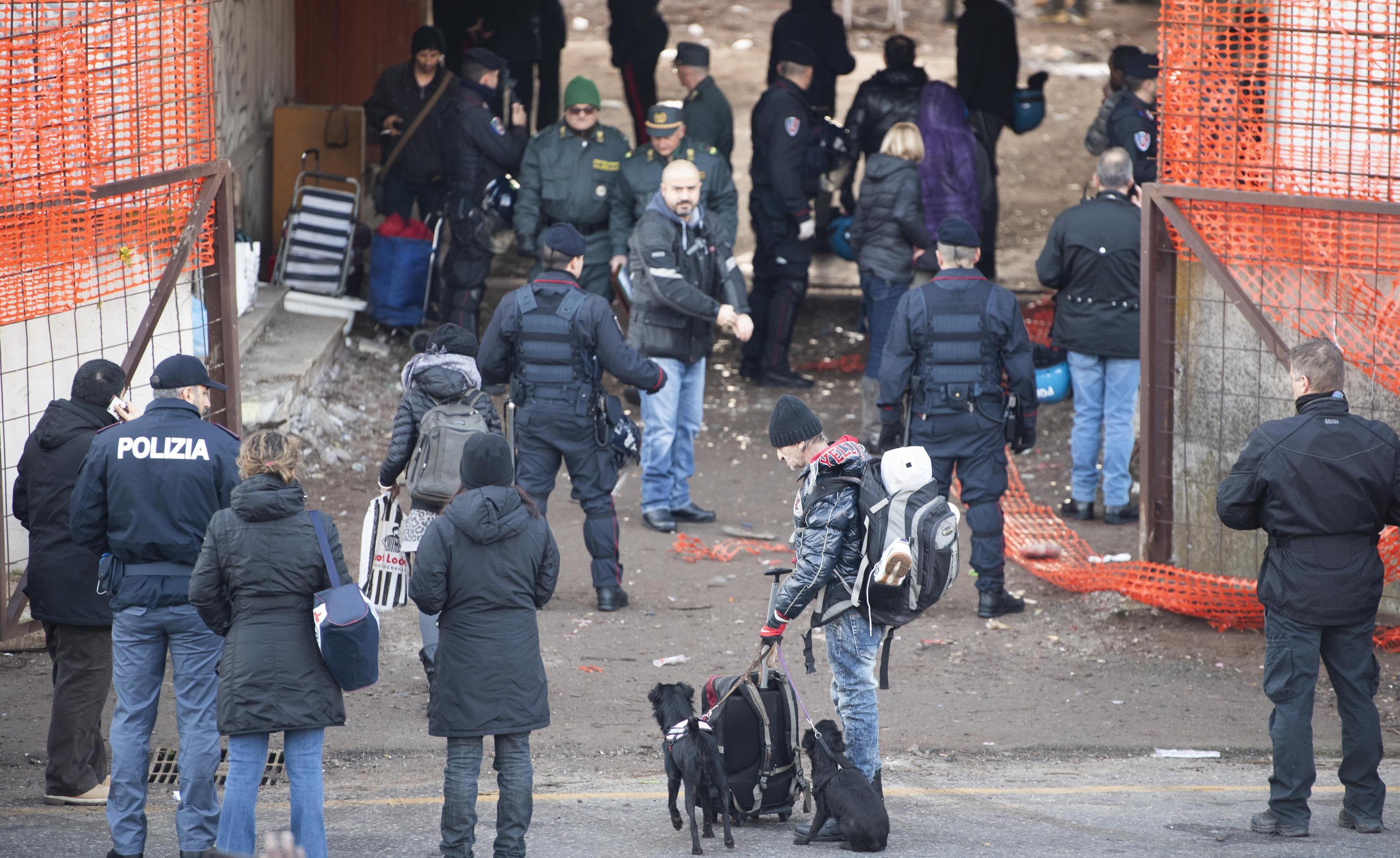 Un momento dello sgombero di via Tiburtina. Al centro della foto Franco e i suoi cani, tra gli sgomberati