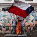 Un manifestante sventola la bandiera cilena davanti al sindacato degli operatori portuali Un manifestante sventola la bandiera cilena davanti al sindacato degli operatori portuali