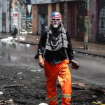 Operaio portuale con una maschera caricaturale degli Usa, in protesta contro il governo a Valparaíso, in Cile Operaio portuale con una maschera caricaturale degli Usa, in protesta contro il governo a Valparaíso, in Cile