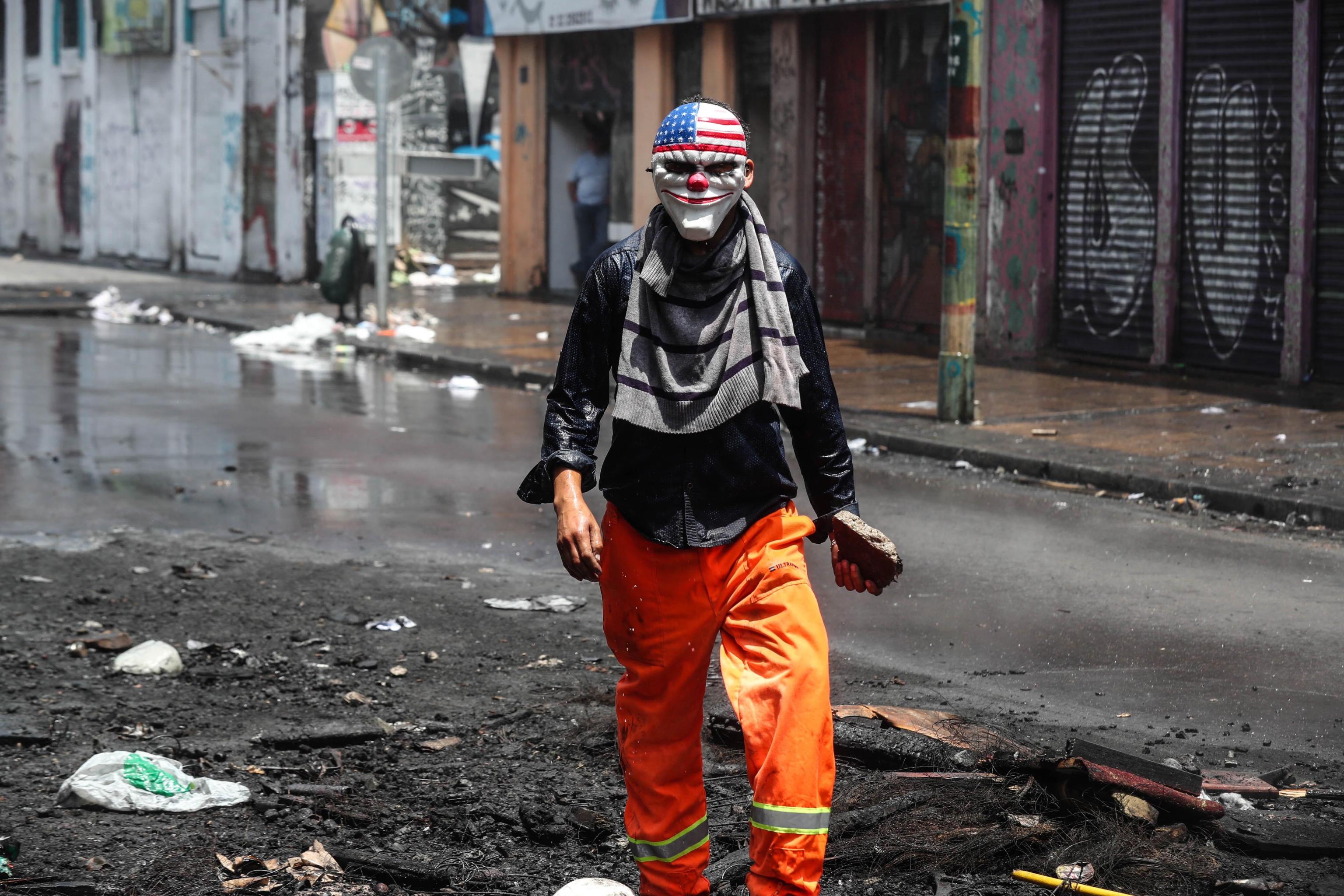 Operaio portuale con una maschera caricaturale degli Usa, in protesta contro il governo a Valparaíso, in Cile Operaio portuale con una maschera caricaturale degli Usa, in protesta contro il governo a Valparaíso, in Cile
