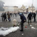 I primi interventi della polizia: un agente spegne un principio di incendio causato da un fumogeno acceso dai tifosi dell'Eintracht