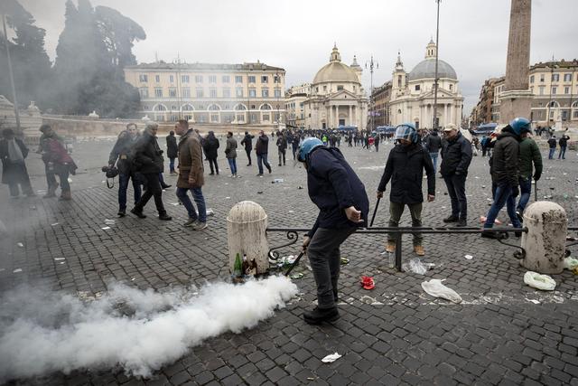 I primi interventi della polizia: un agente spegne un principio di incendio causato da un fumogeno acceso dai tifosi dell'Eintracht