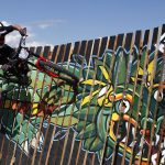 Henry Wilkins, statunitense, esegue un wall-ride su un muro di assi di legno dipinte Henry Wilkins, statunitense, esegue un wall-ride su un muro di assi di legno dipinte