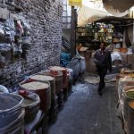 Uno yemenita passeggia lungo le vie anguste del mercato, ricco di prodotti e spezie.