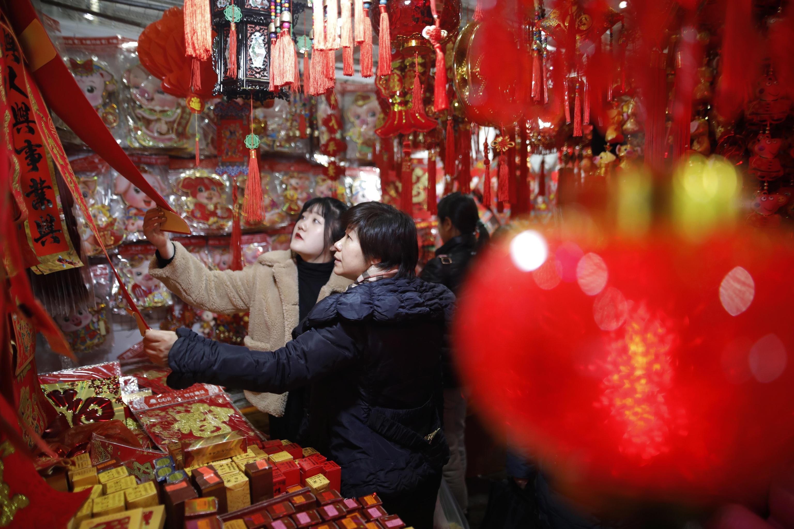Due amiche fanno shopping al mercato di Pechino alla vigilia del capodanno cinese