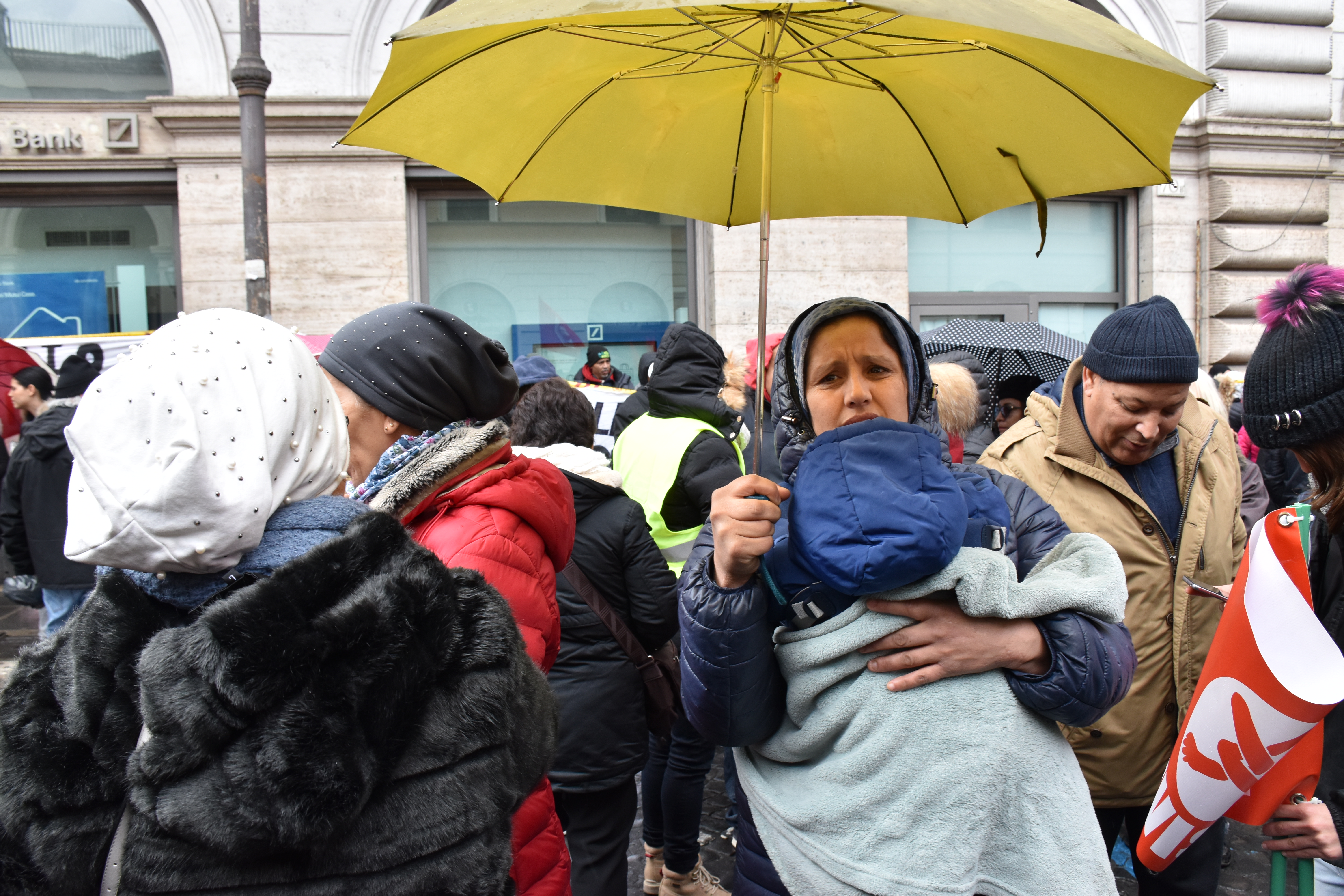 Sotto la pioggia, manifestanti di ogni nazionalità protestano per il diritto alla casa