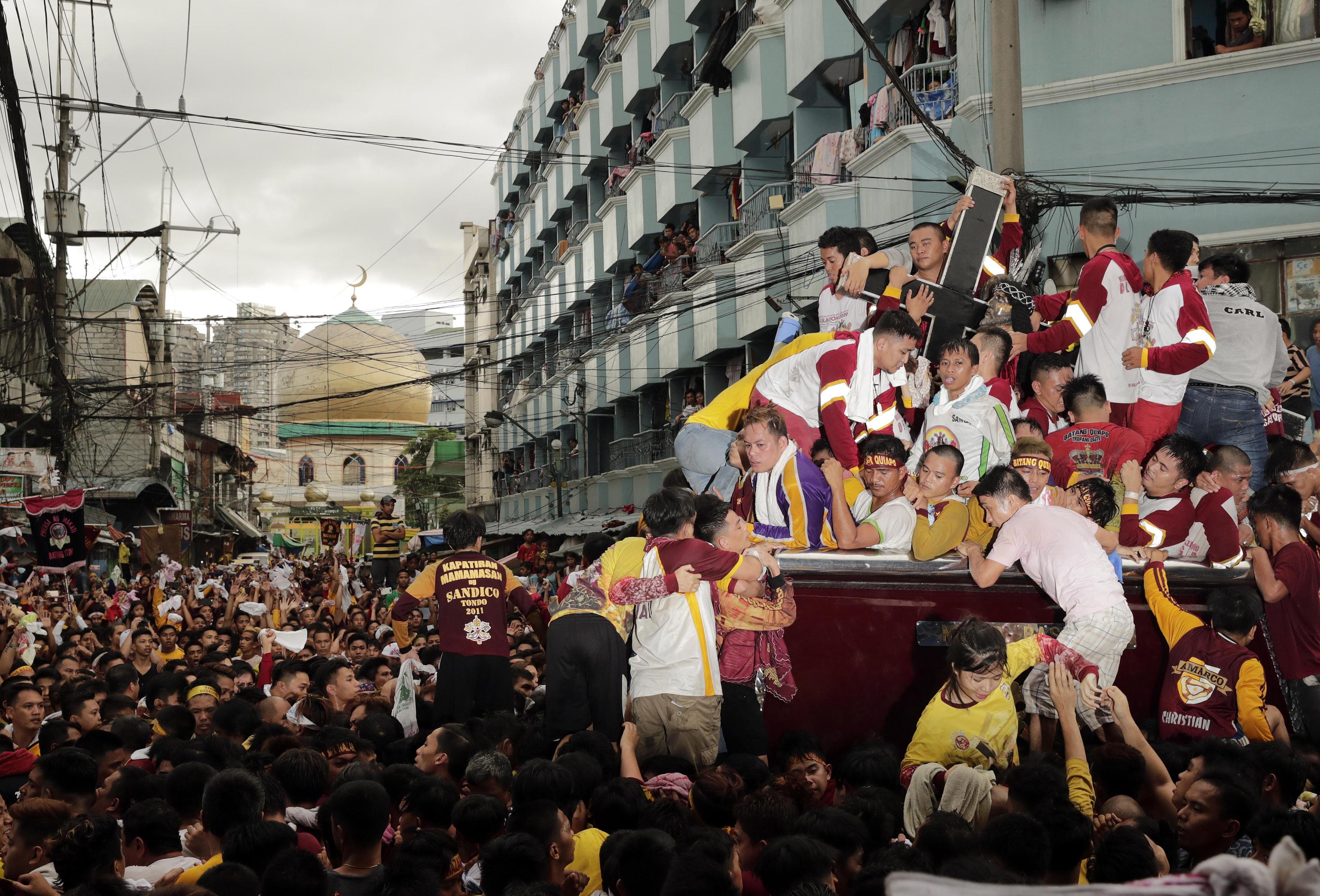 I credenti attraversano le strade di Manila