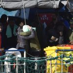 Un abbraccio simbolico tra due delle persone a bordo della Sea Watch. Per loro è la fine di un incubo