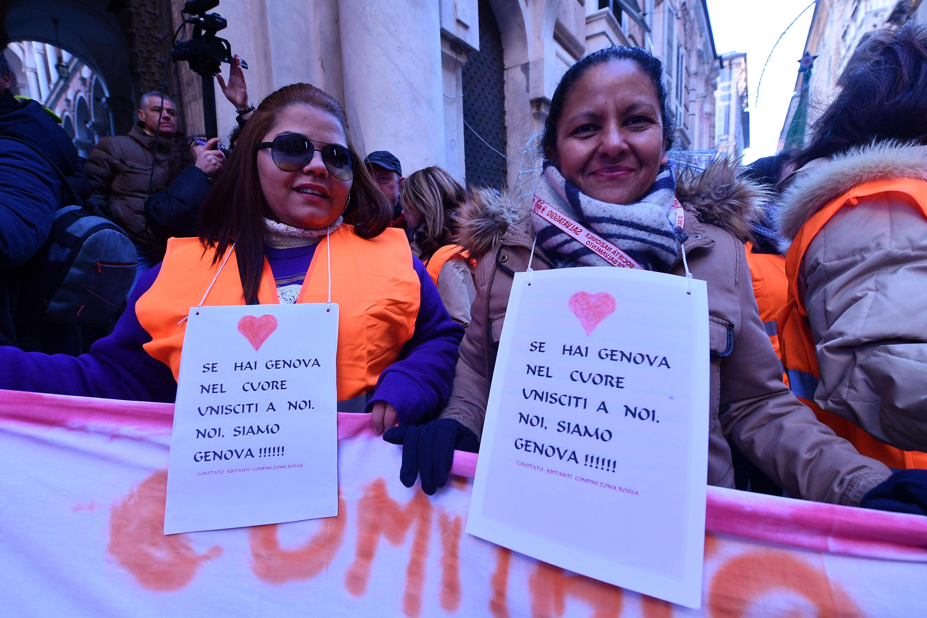 Oltre agli striscioni i manifestanti portano un cartello al collo: "Se hai un cuore unisciti a noi, noi siamo Genova"