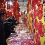 Un cliente guarda le decorazioni di capodanno al mercato di Pechino