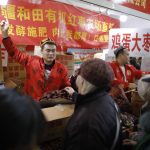 Un venditore espone la merce al mercato di Pechino