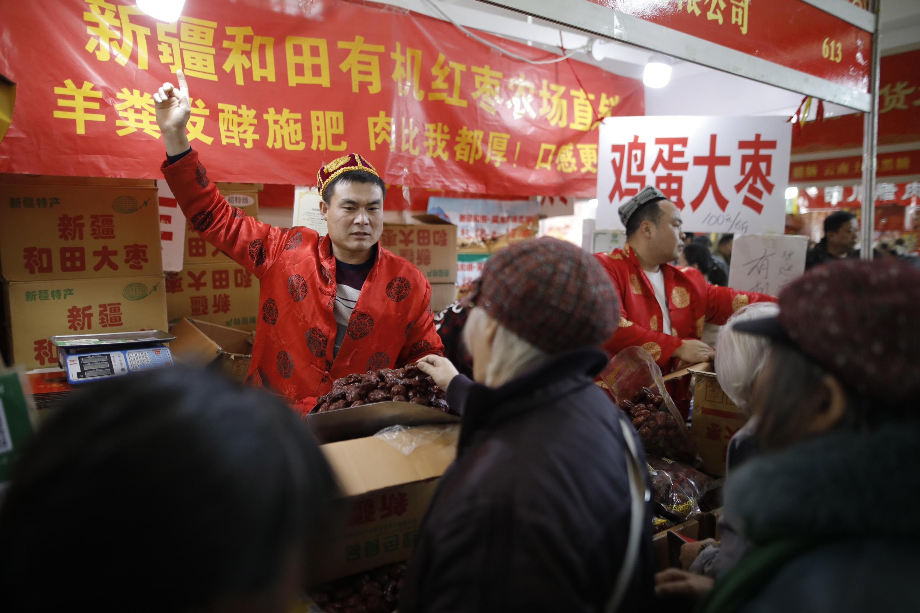 Un venditore espone la merce al mercato di Pechino