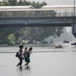Due donne e un bambino honduregni attraversano il fiume Suchiate (Ciudad Hidalgo, Messico). Due donne e un bambino honduregni attraversano il fiume Suchiate (Ciudad Hidalgo, Messico).