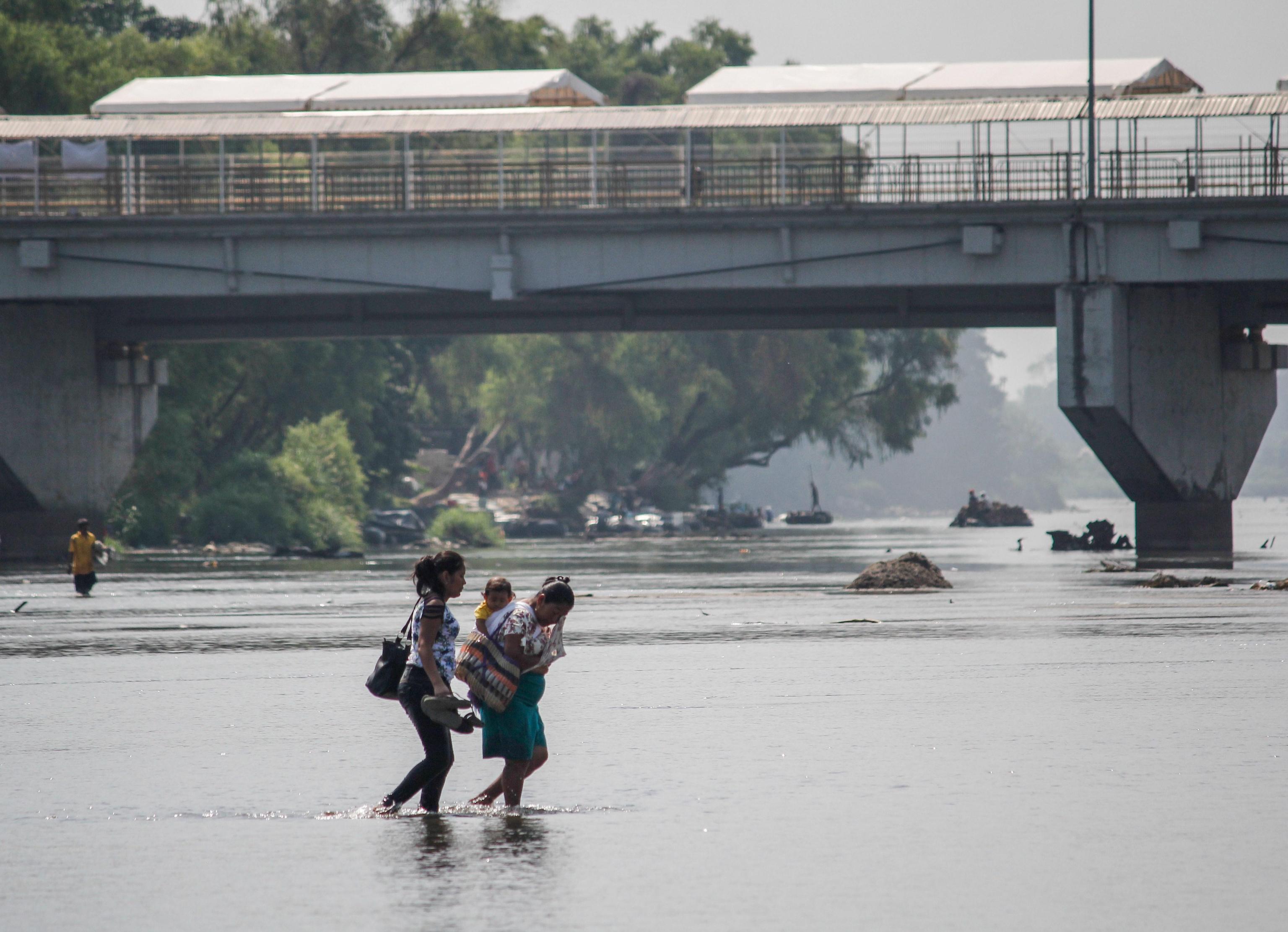 Due donne e un bambino honduregni attraversano il fiume Suchiate (Ciudad Hidalgo, Messico). Due donne e un bambino honduregni attraversano il fiume Suchiate (Ciudad Hidalgo, Messico).