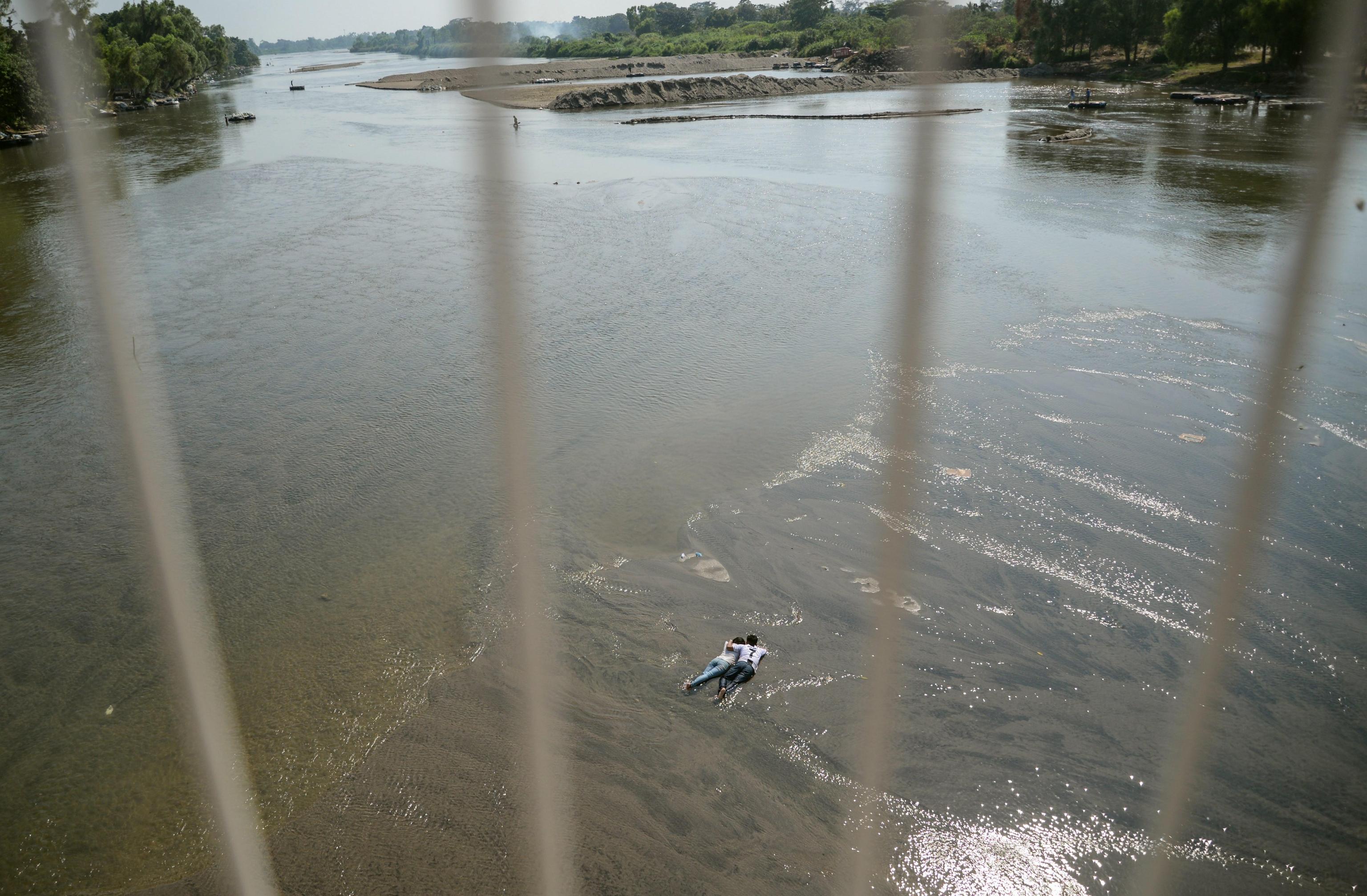 Due giovani migranti distesi abbracciati sul letto del fiume Suchiate (Ciudad Hidalgo, Messico) Due giovani migranti distesi abbracciati sul letto del fiume Suchiate (Ciudad Hidalgo, Messico)