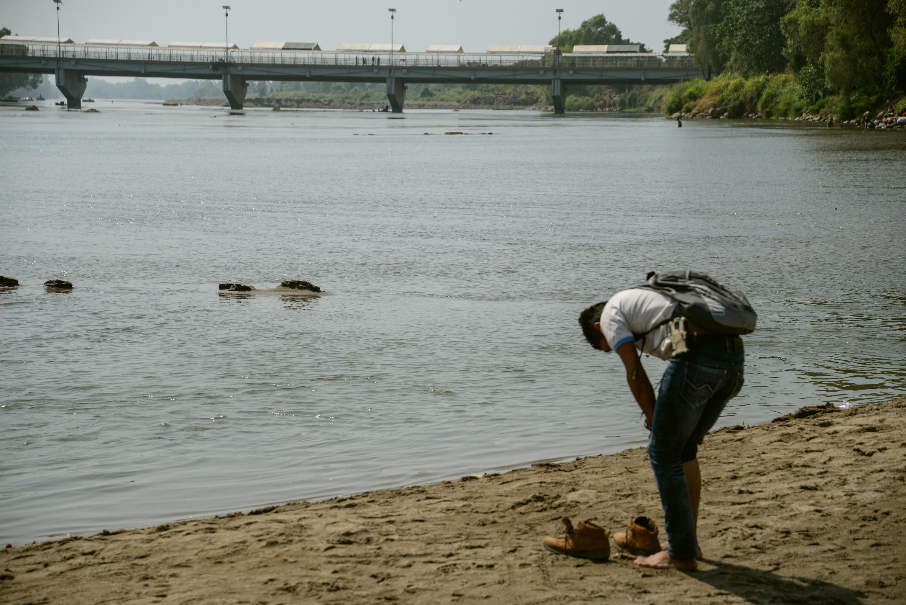 Un honduregno si toglie le scarpe per attraversare il fiume Suchiate (Ciudad Hidalgo, Messico). La meta finale sono gli Stati Uniti Un honduregno si toglie le scarpe per attraversare il fiume Suchiate (Ciudad Hidalgo, Messico). La meta finale sono gli Stati Uniti