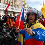 Tra le strade di Caracas con moto e bandiere