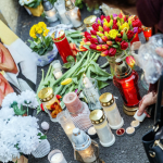 Alcuni manifestanti accendono candele accanto alla foto di Jan Kuciak Alcuni manifestanti accendono candele accanto alla foto di Jan Kuciak