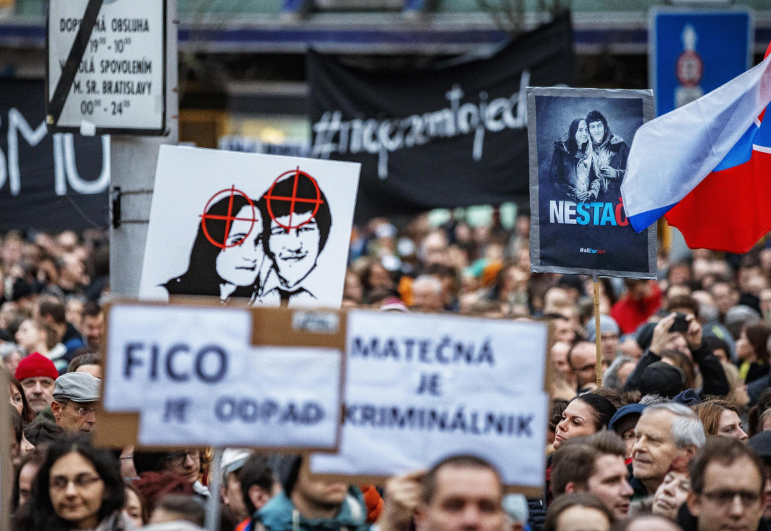 Cartellone che ritrae Jan Kuciak e la compagna Martina Kusnirova al centro di un mirino Cartellone che ritrae Jan Kuciak e la compagna Martina Kusnirova al centro di un mirino