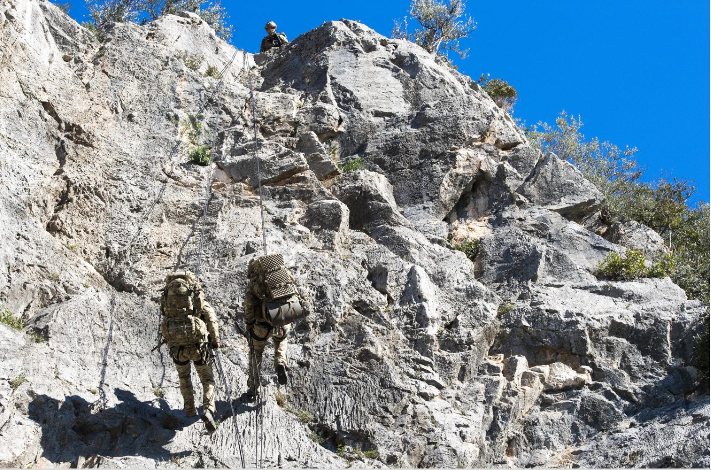 I soldati marciano verso la parete rocciosa