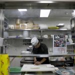 Uno chef cinese prepara un sashimi