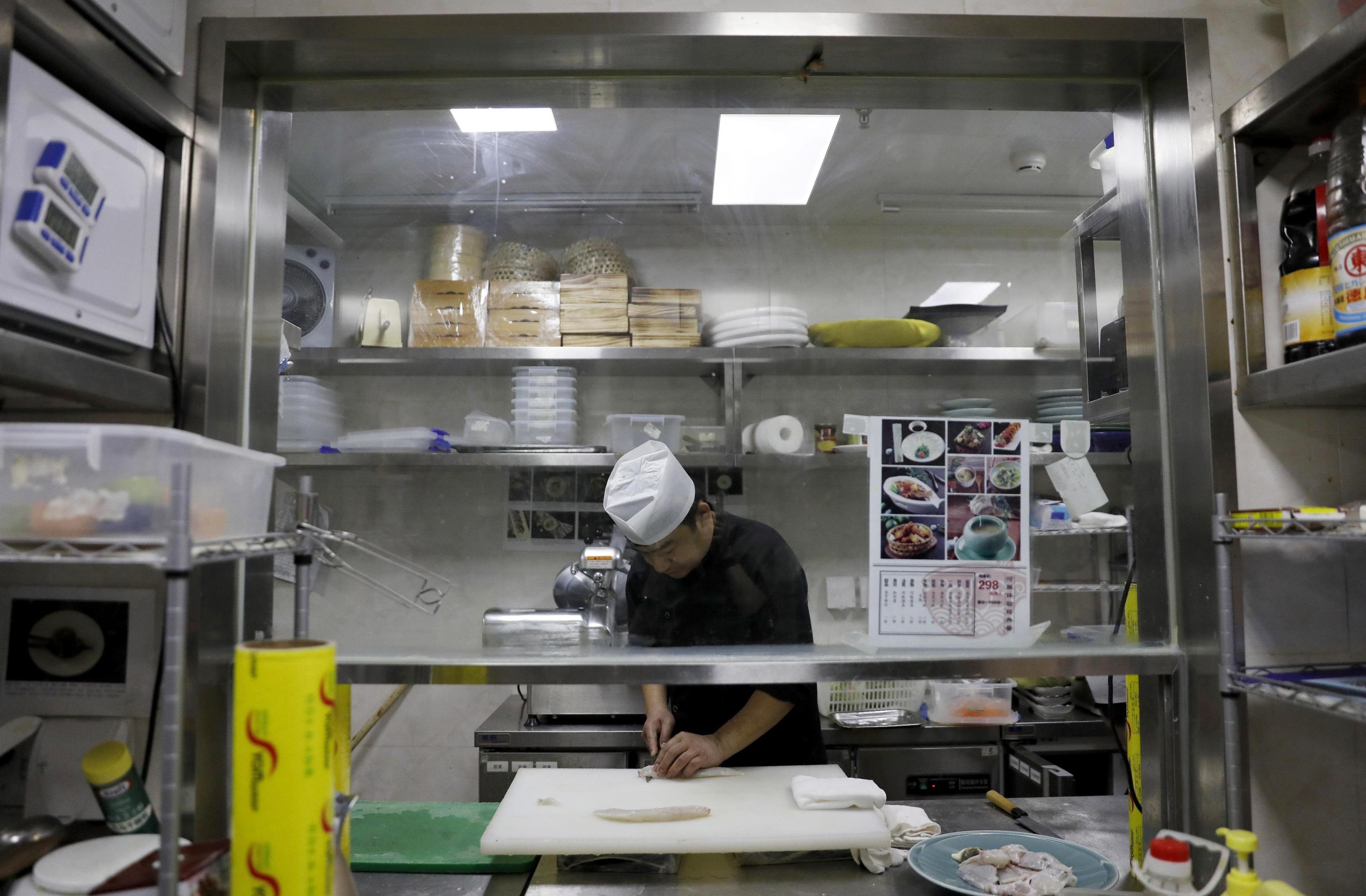 Uno chef cinese prepara un sashimi