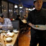 Un cameriere serve i clienti