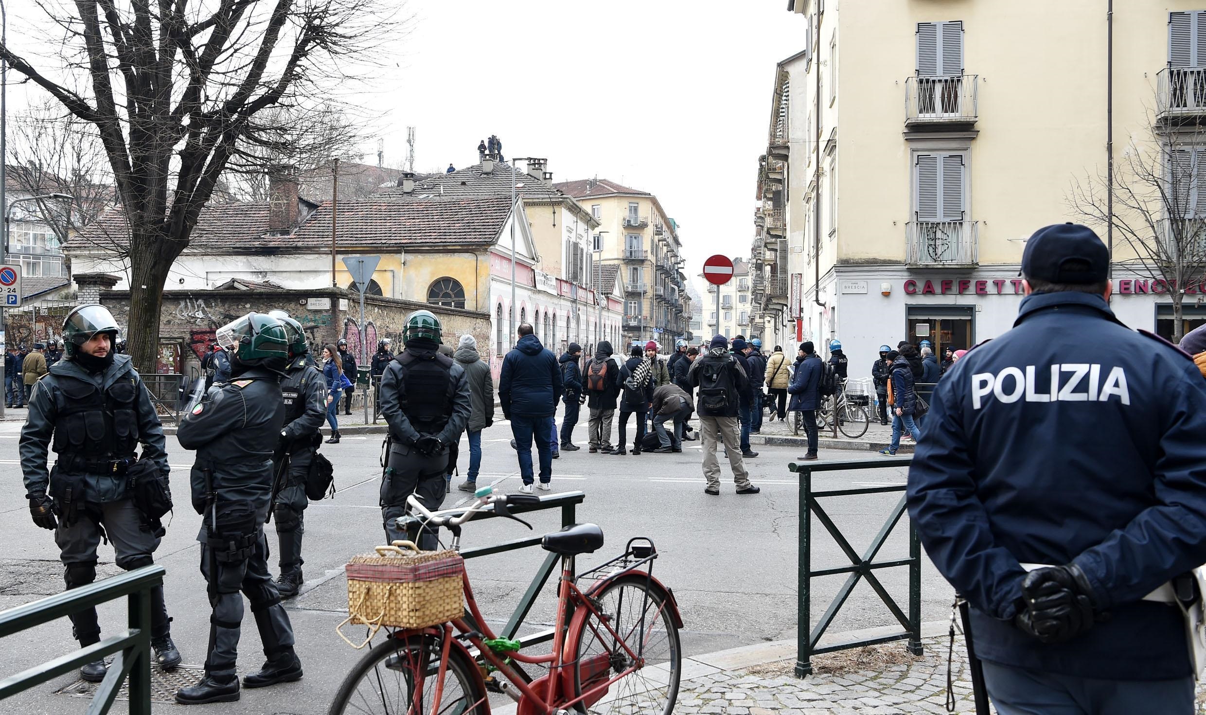 La polizia in strada, vicino al luogo dello sgombero, dove si sono radunati gruppi di persone