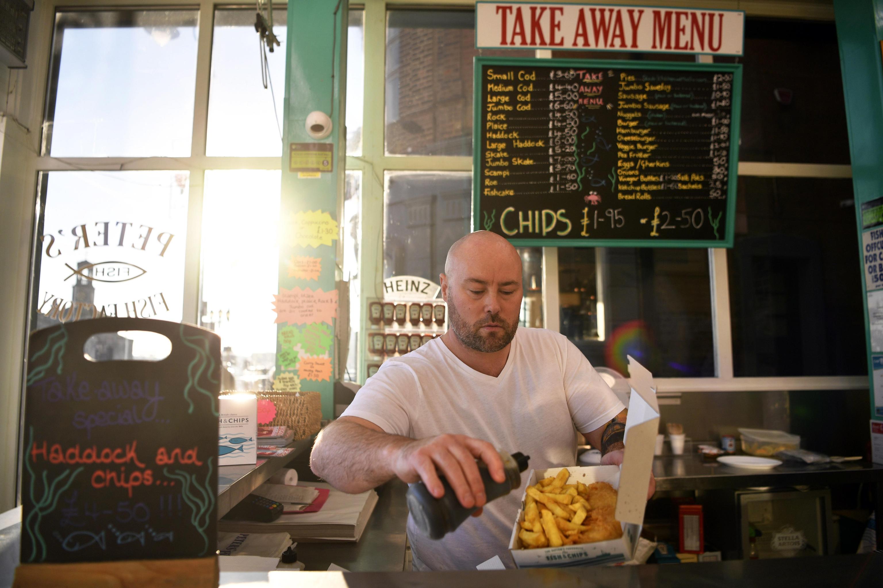 Il commerciante Karld Serveld versa aceto in una porzione di fish and chips a Ramsgate, in Gran Bretagna. La maggior parte del suo pesce è importato dalla Scandinavia, perciò potrebbe avere problemi dopo la Brexit.