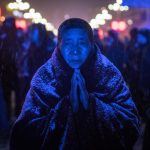 Una suora buddista prega durante una cerimonia con sculture fatte di burro di yak nel monastero di Labrang