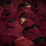 Dettaglio dei monaci buddisti, nei loro abiti tradizionali, mentre aspettano di pregare