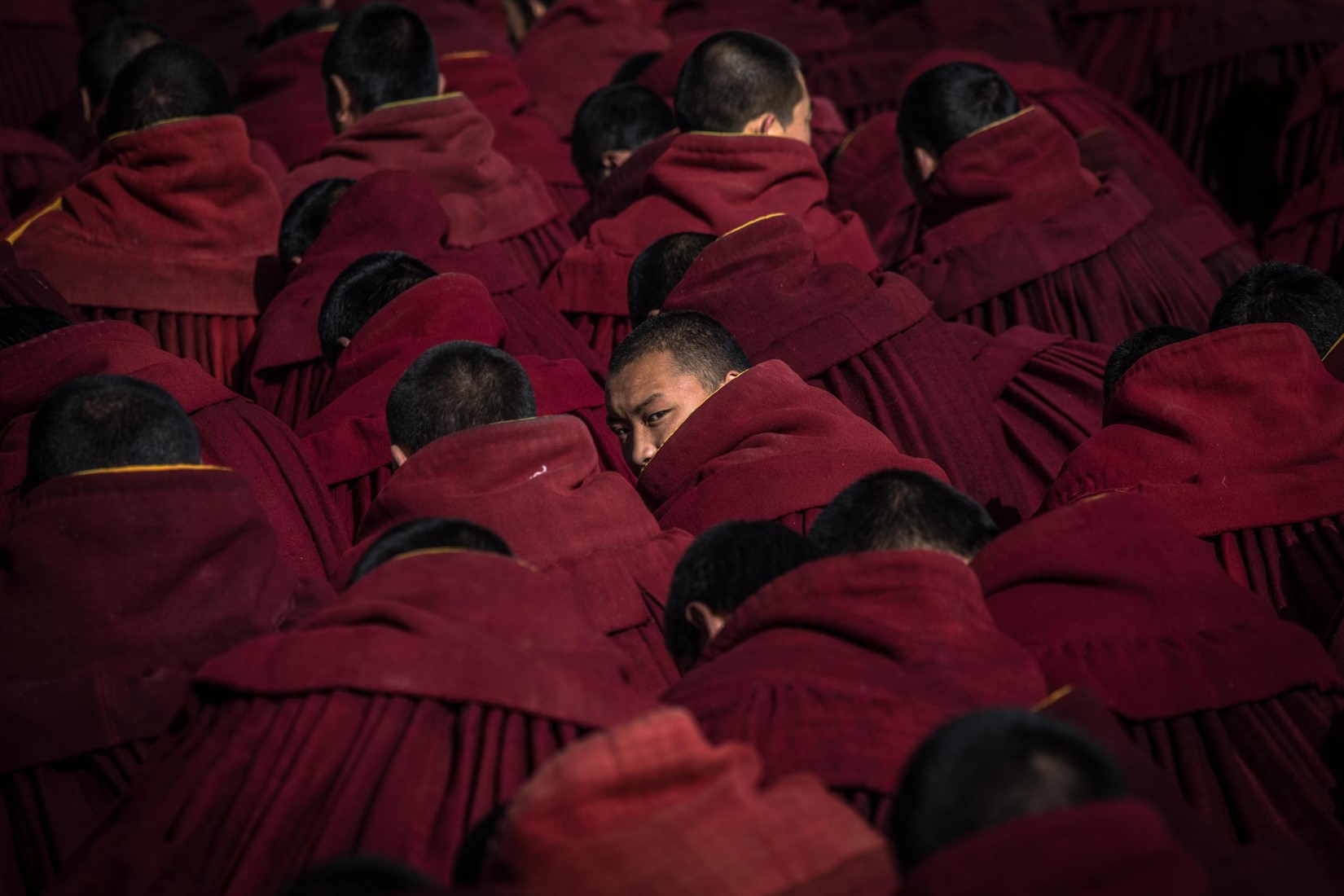 Dettaglio dei monaci buddisti, nei loro abiti tradizionali, mentre aspettano di pregare