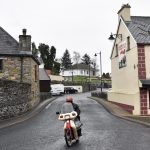 Un uomo in motocicletta attraversa il confine passando sopra il ponte sul fiume Termon Un uomo in motocicletta attraversa il confine passando sopra il ponte sul fiume Termon