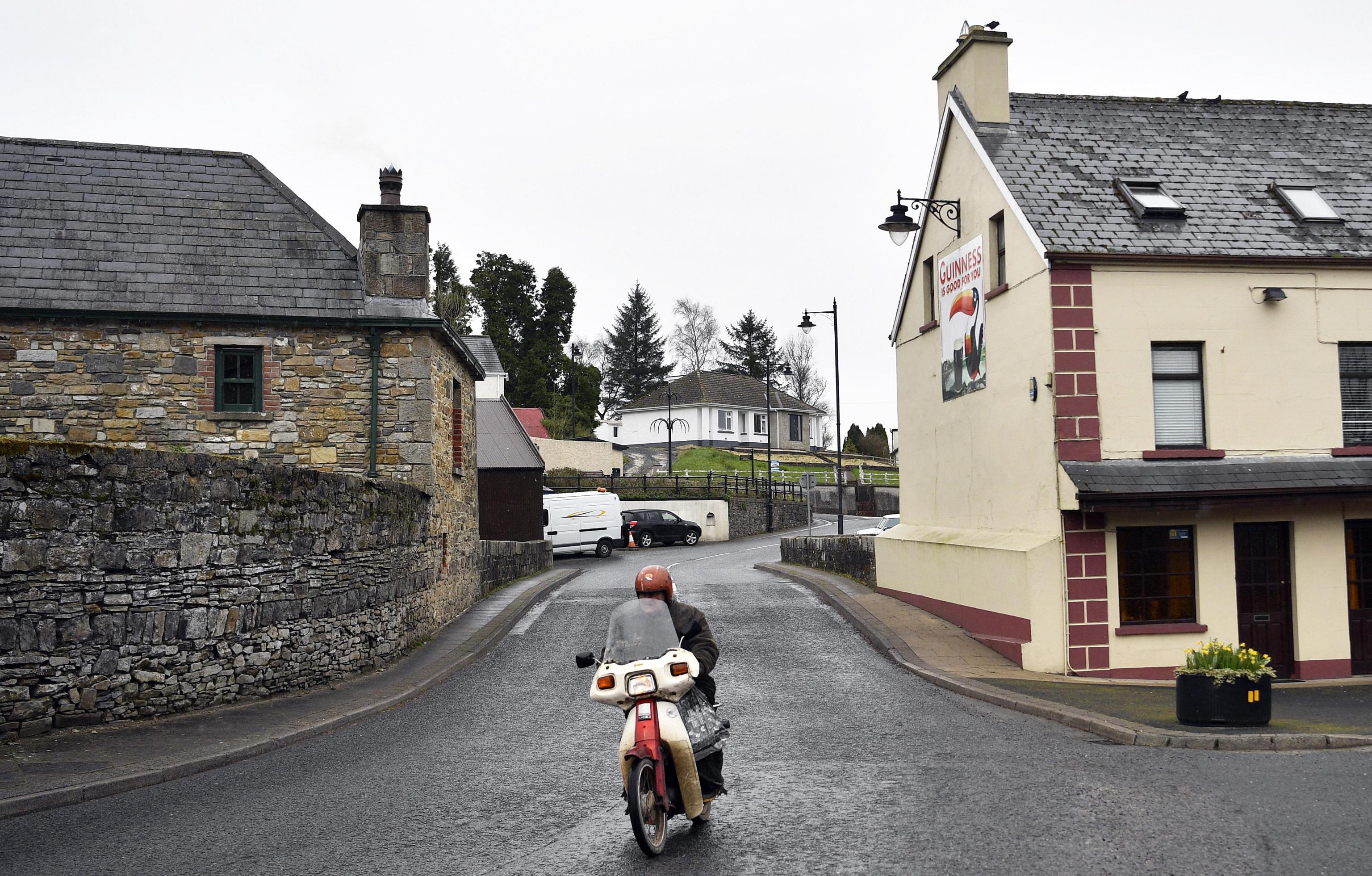 Un uomo in motocicletta attraversa il confine passando sopra il ponte sul fiume Termon Un uomo in motocicletta attraversa il confine passando sopra il ponte sul fiume Termon