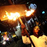 Un uomo con una fiaccola durante la marcia della Krewe of Bacchus