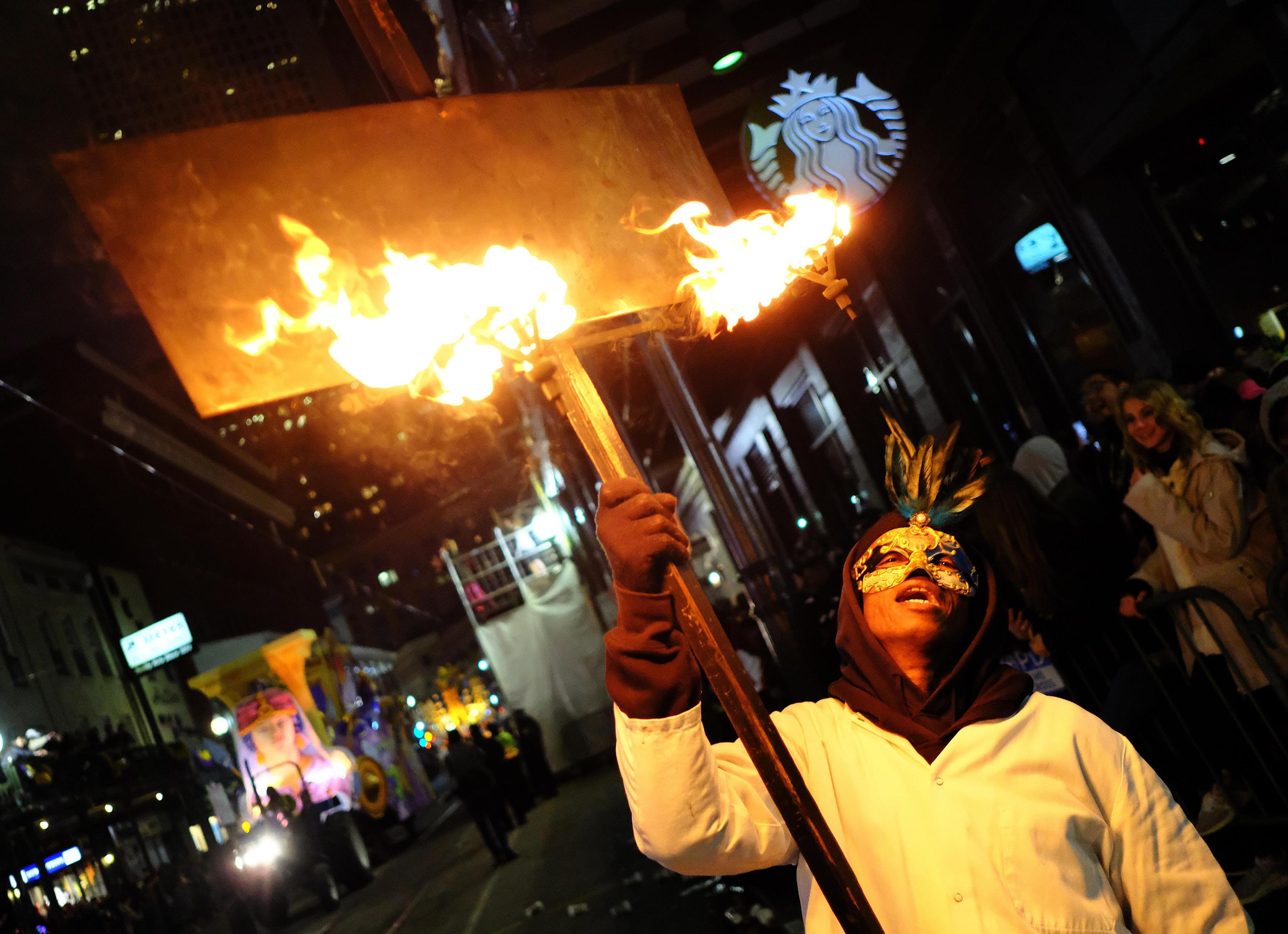 Un uomo con una fiaccola durante la marcia della Krewe of Bacchus