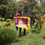 Un protestante con in mano la bandiera tibetana Un protestante con in mano la bandiera tibetana