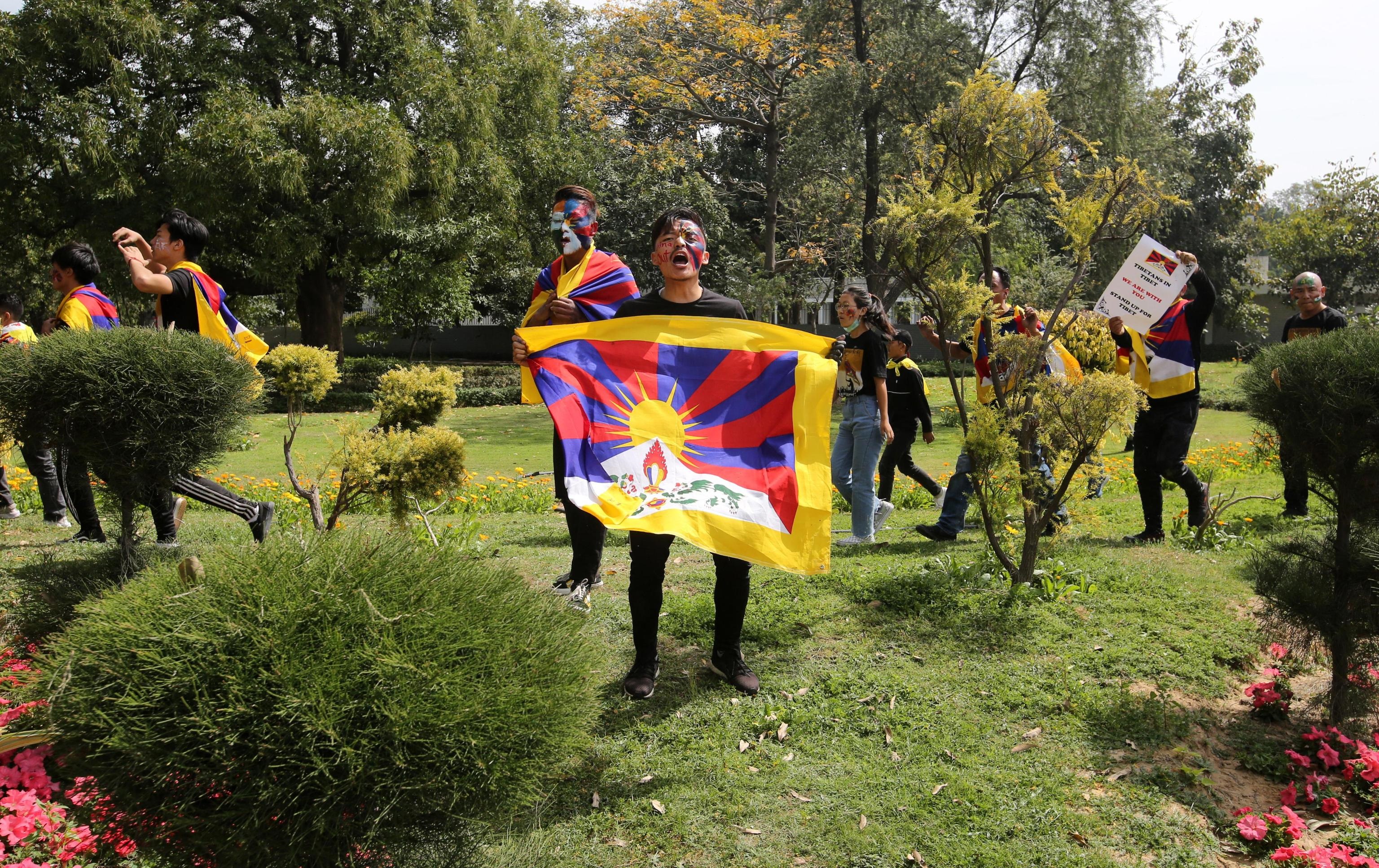 Un protestante con in mano la bandiera tibetana Un protestante con in mano la bandiera tibetana