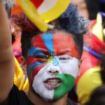 Un uomo con la bandiera tibetana pitturata sul volto Un uomo con la bandiera tibetana pitturata sul volto